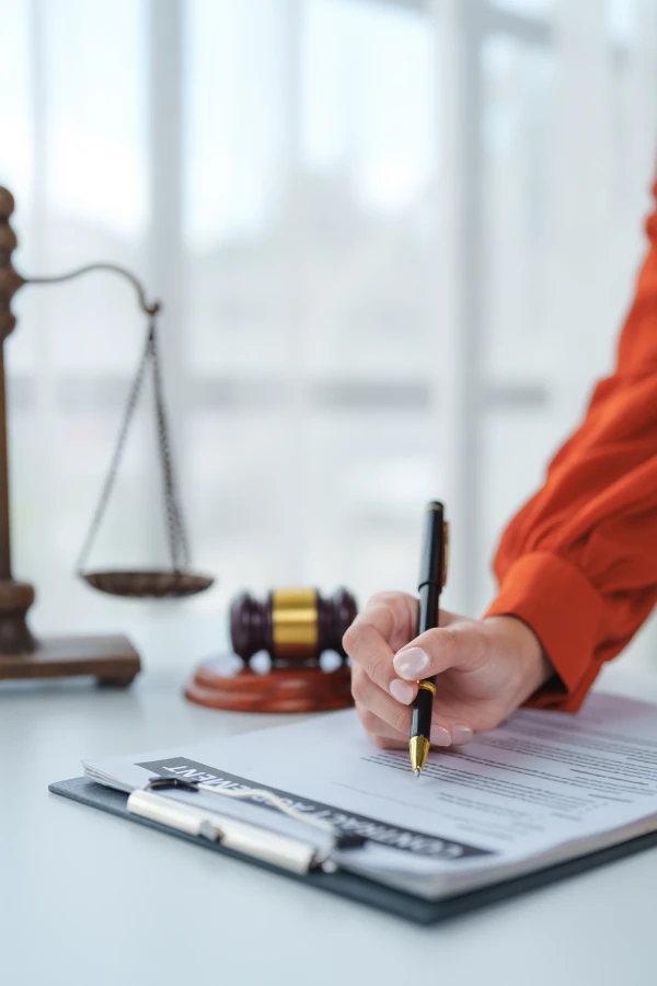 Signing legal document with scales and gavel