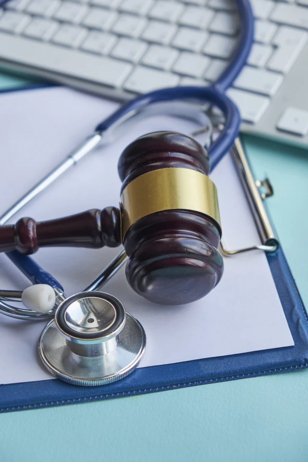 Gavel and stethoscope on clipboard